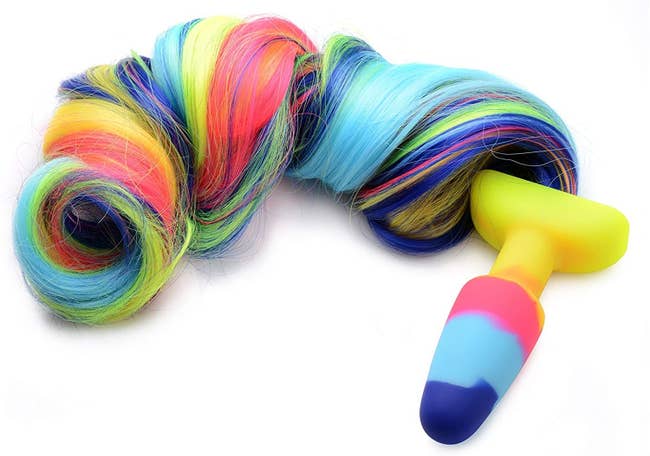Vibrant multicolor butt plug attached to multicolor synthetic unicorn tail