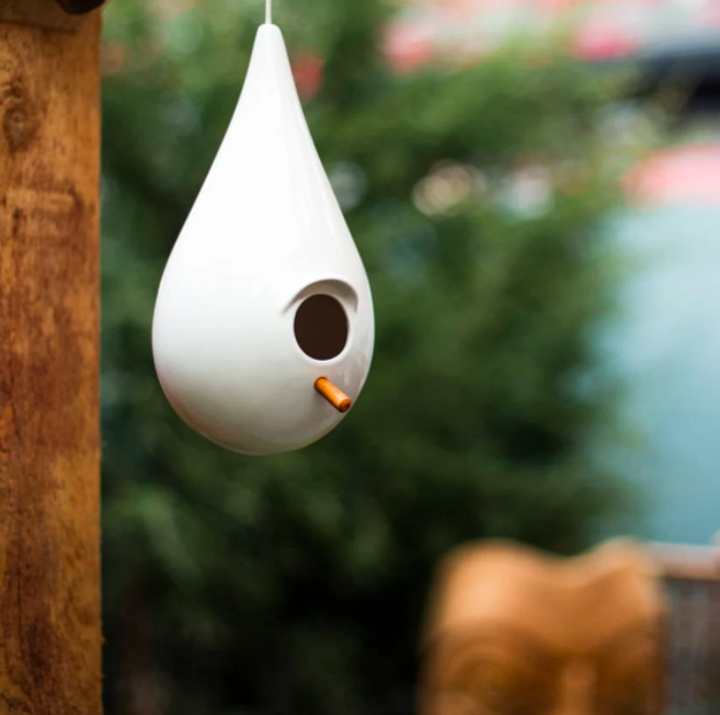 A porcelain birdhouse shaped like a large water droplet