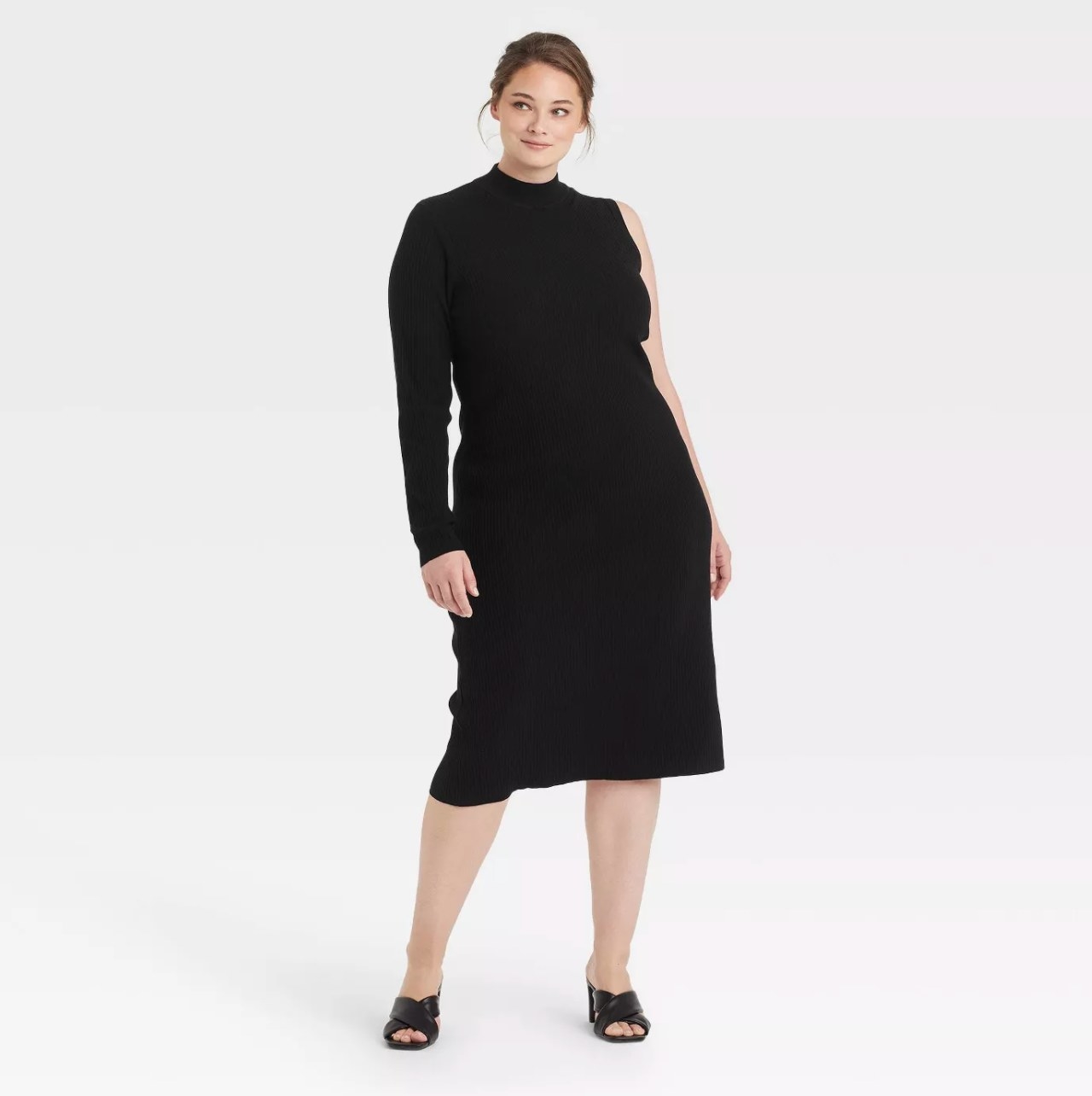 Model in a black midi dress with one long sleeve and one sleeveless