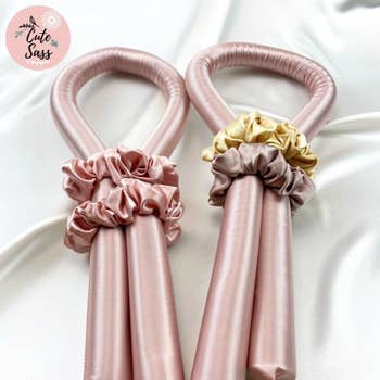 two of the pink curling wands with scrunchies wrapped around them
