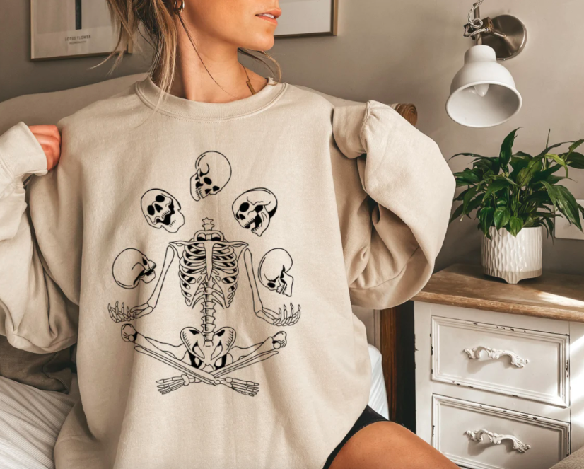 a person wearing an oversized sweatshirt with a skeleton graphic on the front