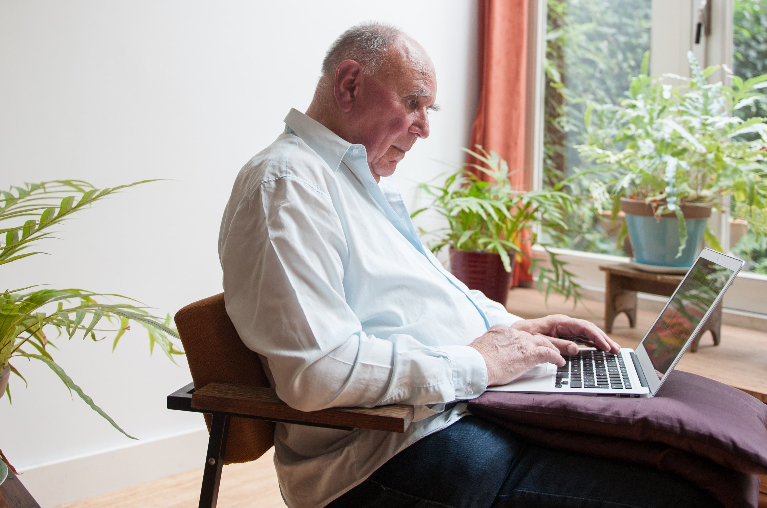 Photo of an old man on a computer