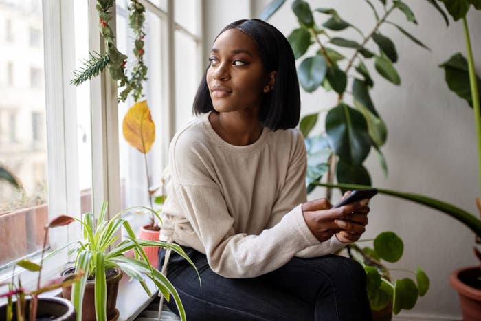 Someone sits alone at home, looking like they're at peace