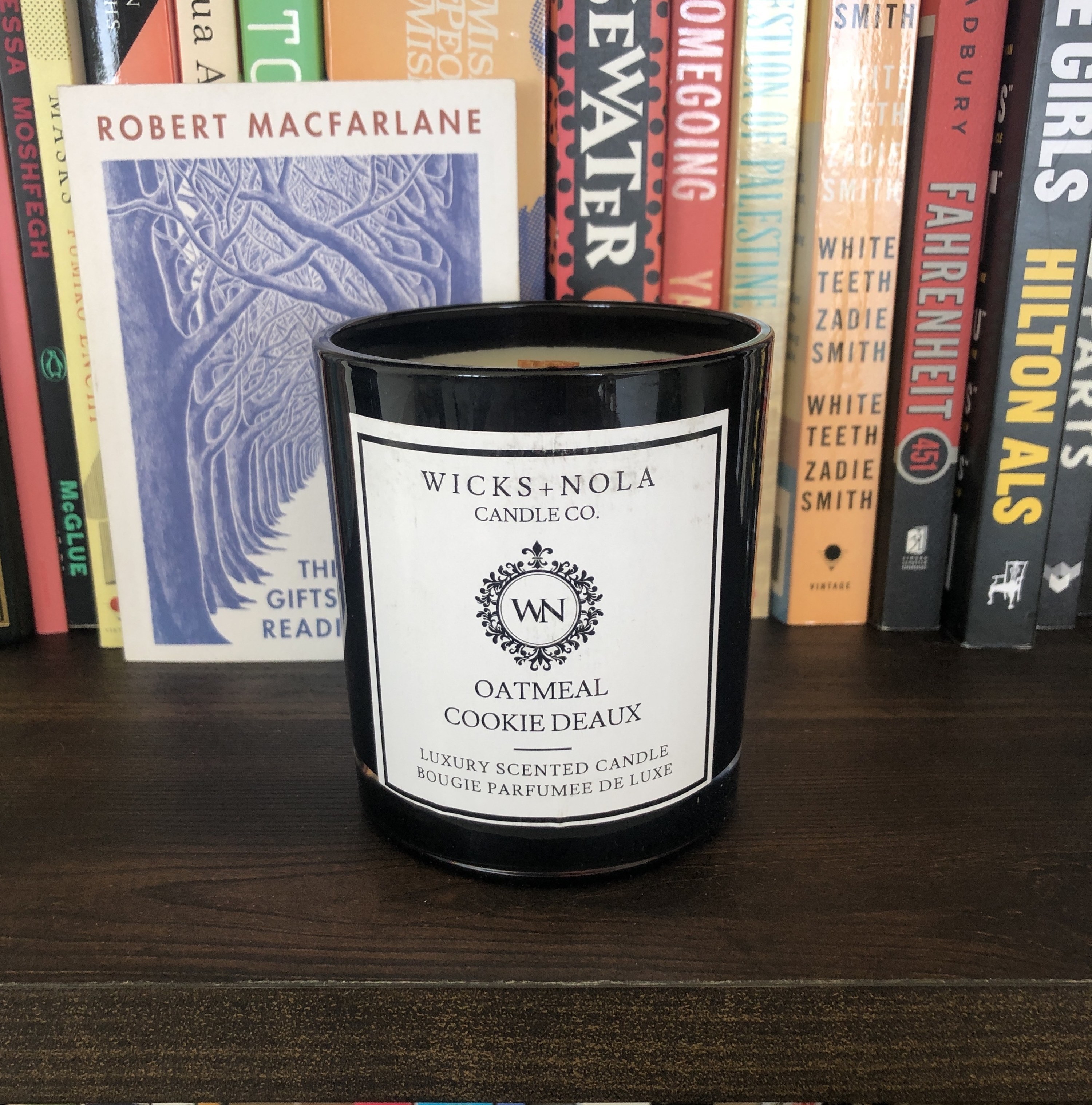 The candle is shown on a bookshelf