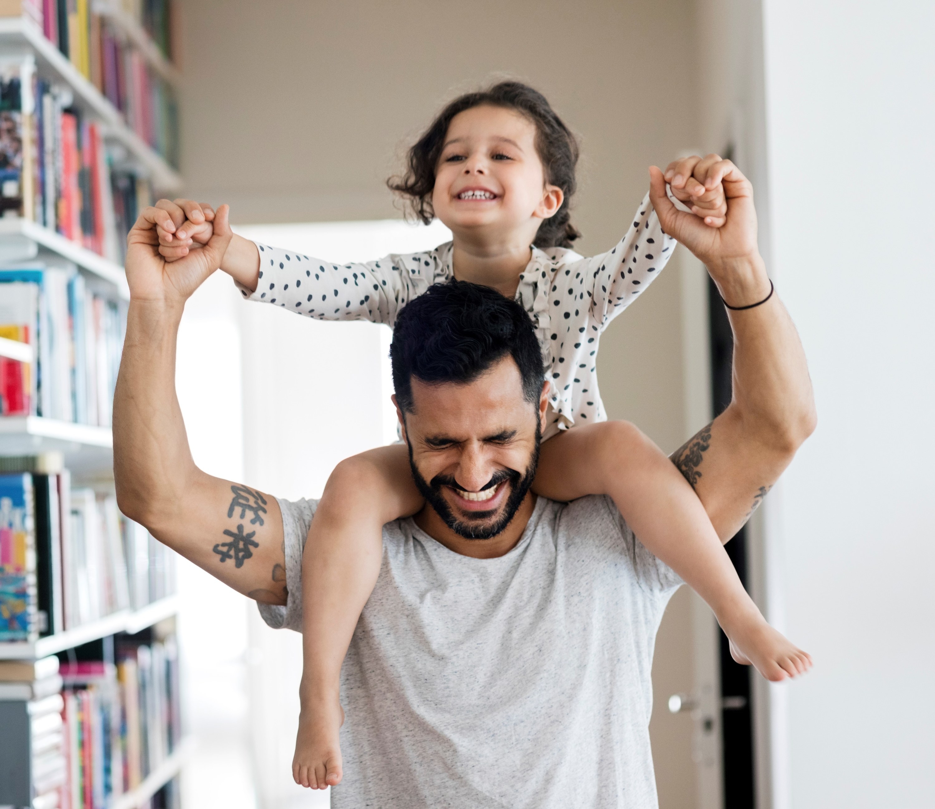 Photo of a dad with a kid on their shoulders