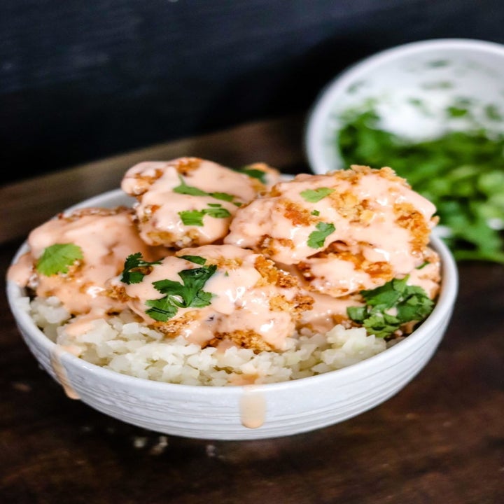 A bowl of bang bang shrimp over rice.