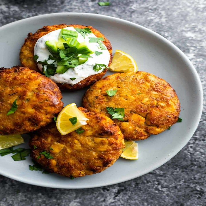 Salmon patties with dipping sauce and lemon.