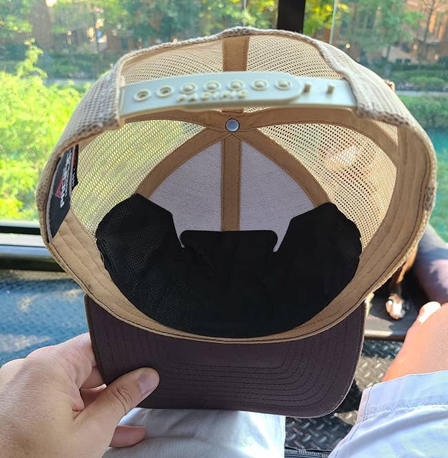 a reviewer holding a hat with the liner applied on the inside