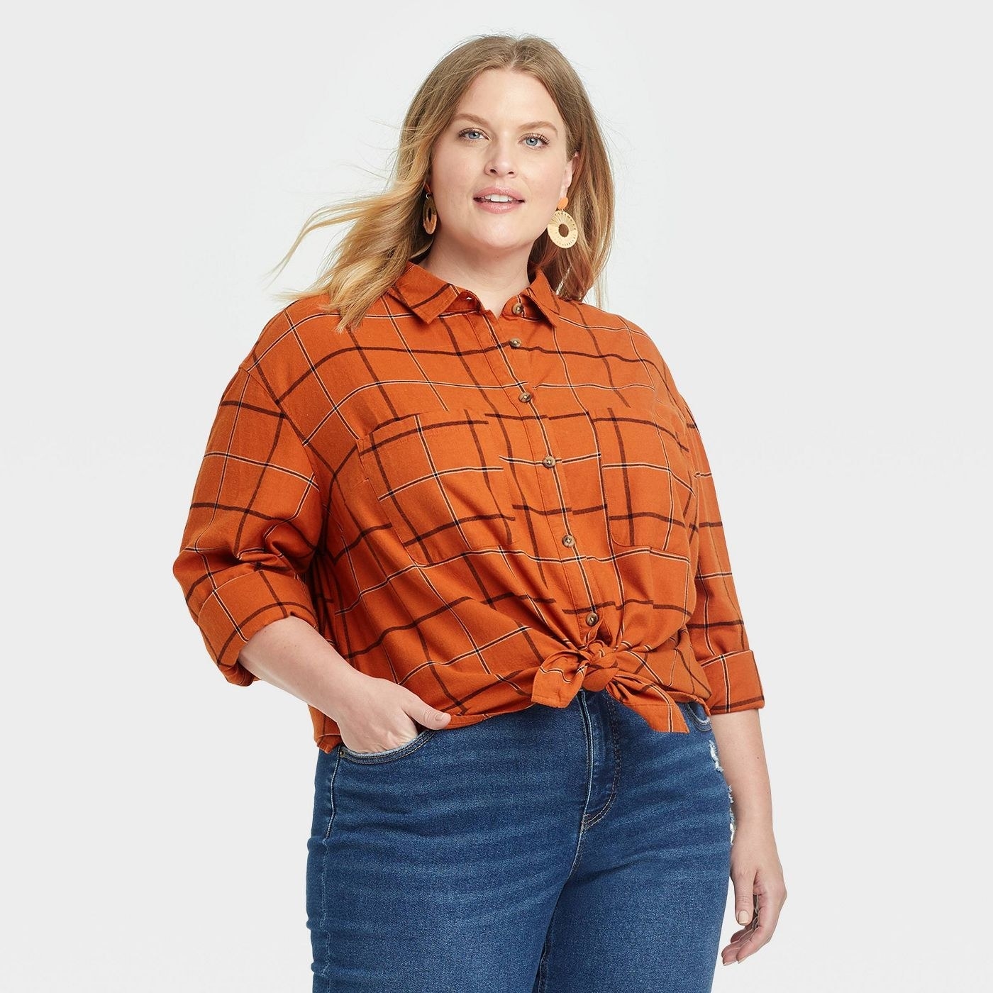 Model wearing the rust plaid long-sleeve button down flannel tunic top