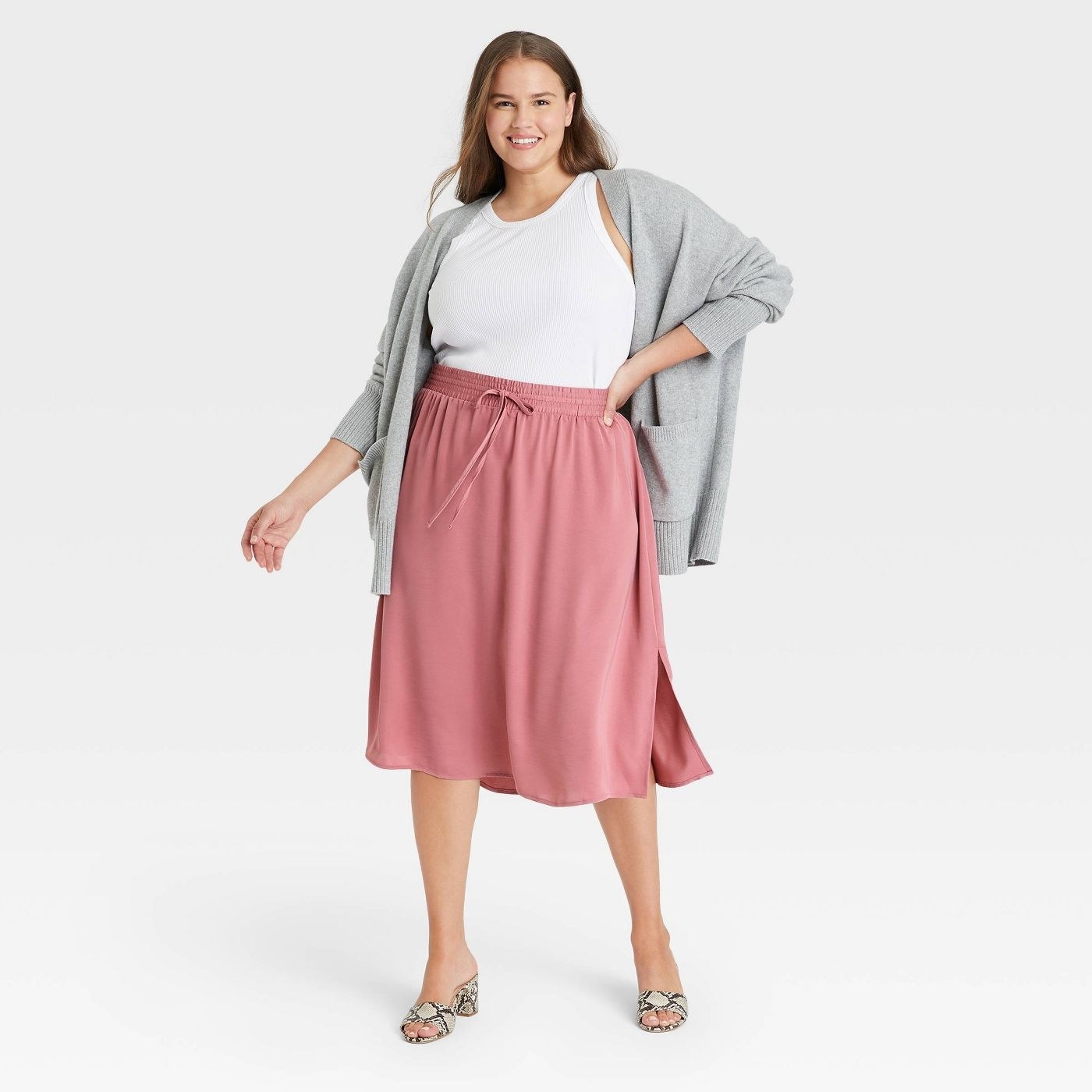 Model wearing the pink high-rise midi slip skirt