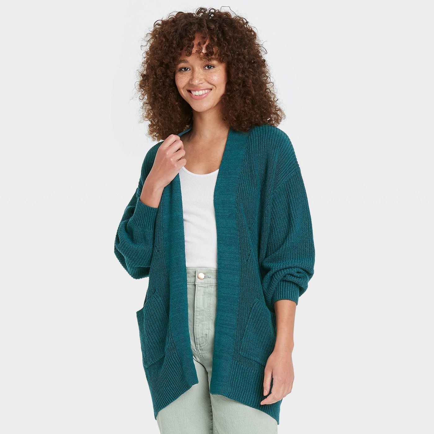 Model wearing the teal open-front cardigan