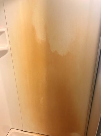 reviewer's shower covered in a large rust stain