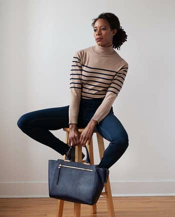 Reviewer wearing the tan and black striped turtleneck