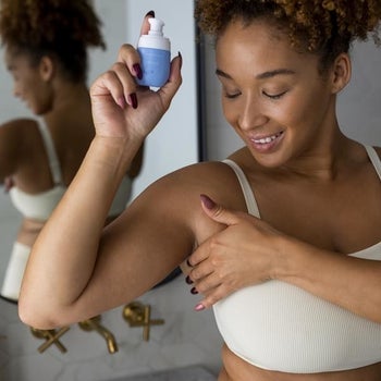 a model holding the product and applying it to their underarm