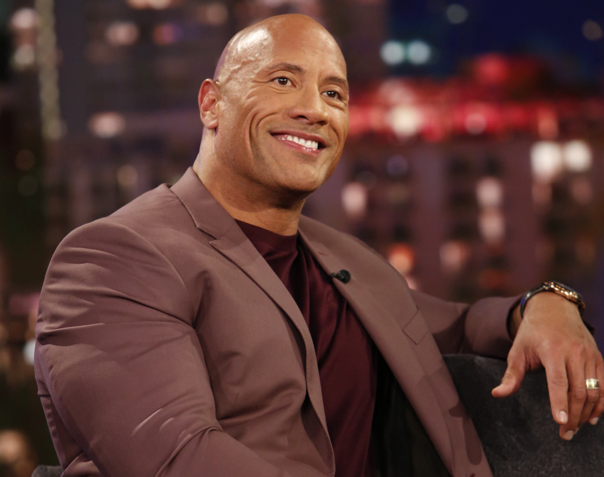 Dwayne Johnson smiles on a night show.