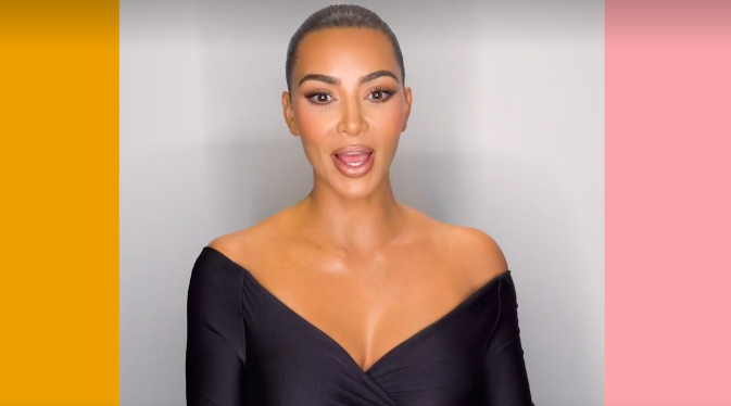 Kim with her hair pulled back and waring an off-the-shoulder V-neck top