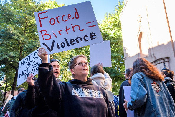 A protest sign that says &quot;forced birth = violence&quot;