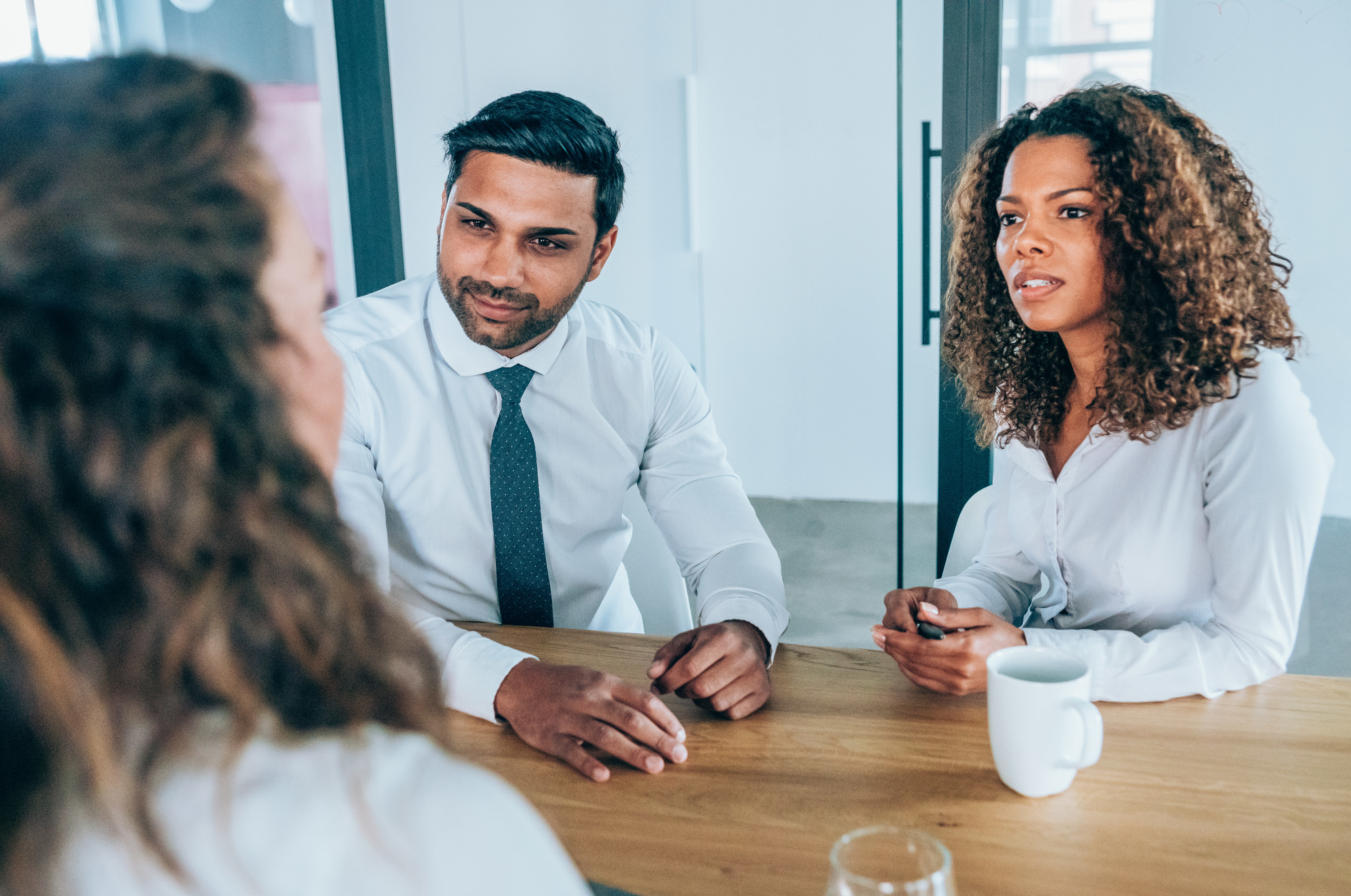 Woman talking with two interviewers in an office