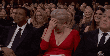 Meryl Streep laughing at an awards show as she sits next to Denzel Washington