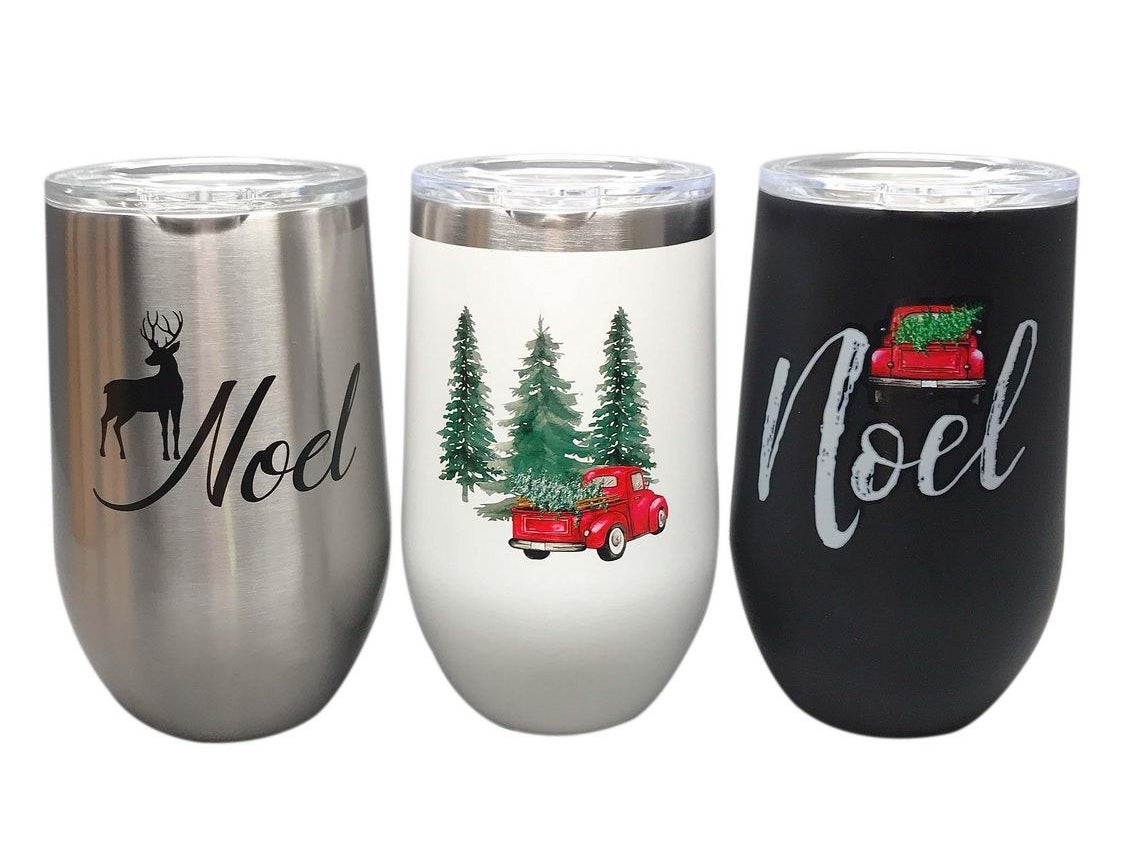 three tumblers that say noel and have trucks with trees in them