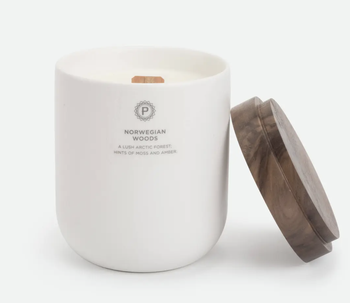 a white ceramic candle jar with a white soy wax candle with a wood wick in it
