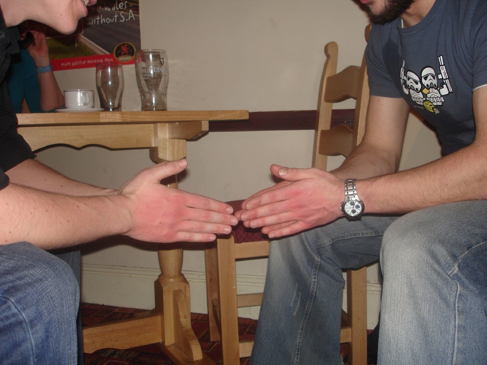 A close up of two pairs of hands folded and touching each other