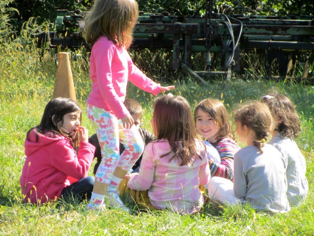 A group of kids playing duck, duck, goose