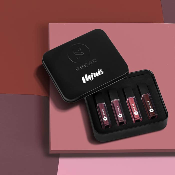 A box with lipsticks in it next to a pink background