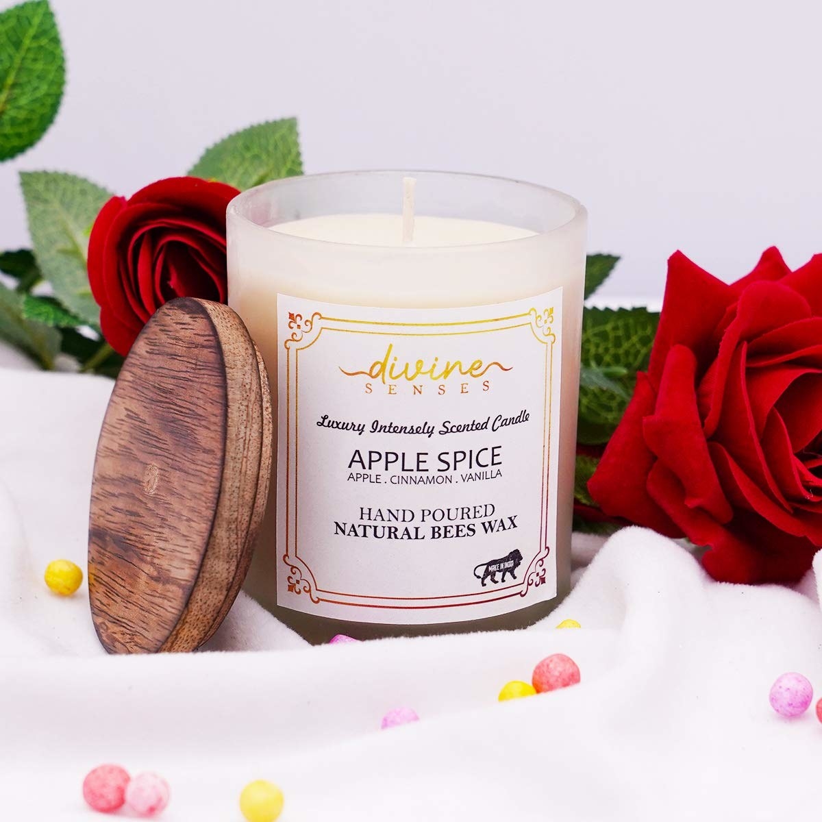A hand-poured candle next to a rose with confetti balls