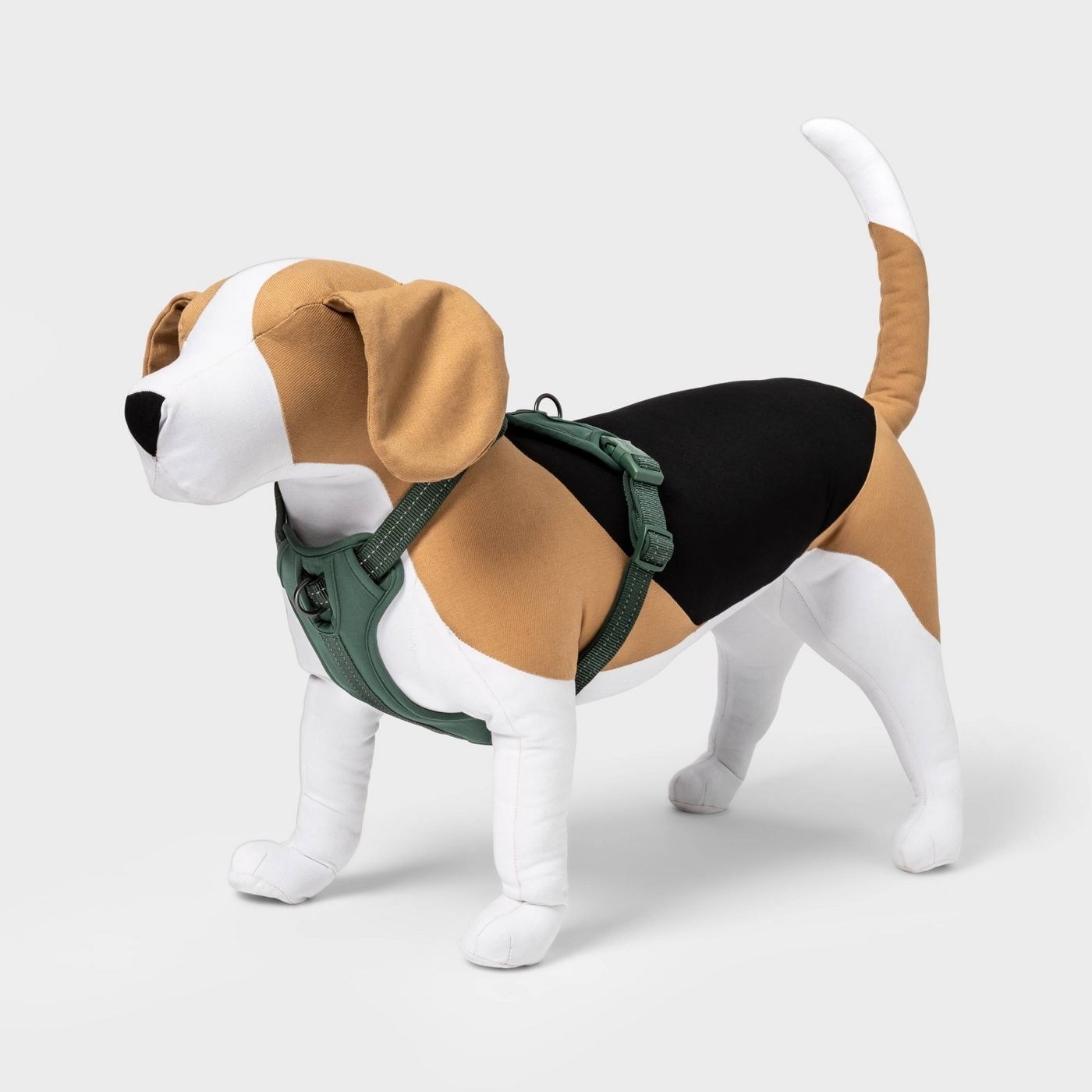green dog harness on. stuffed animal dog