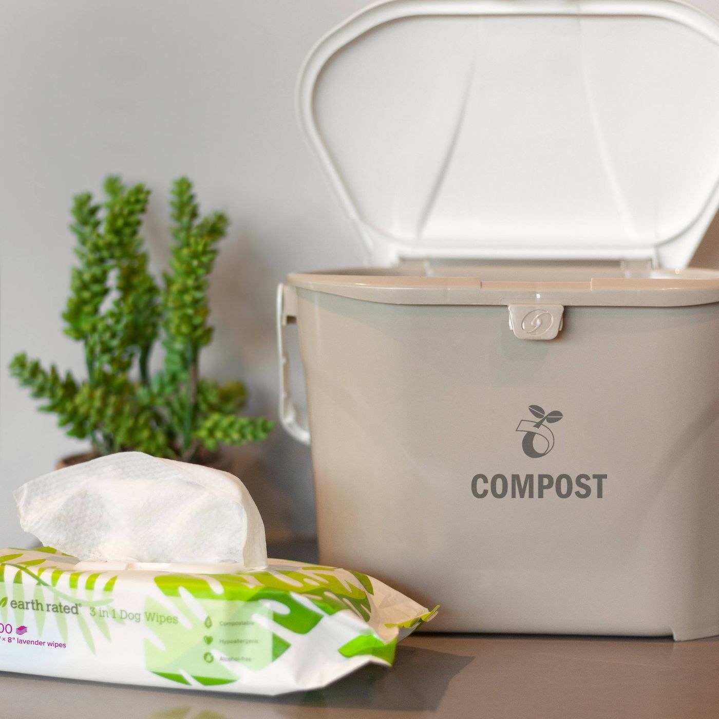 pack of compostable pet wipes next to a compost bin