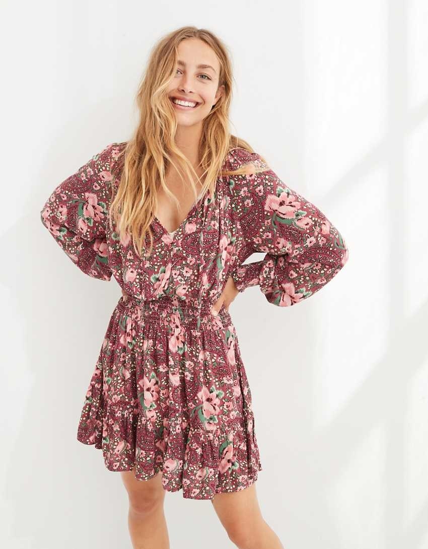 model wearing the pink floral dress with hands on their hips