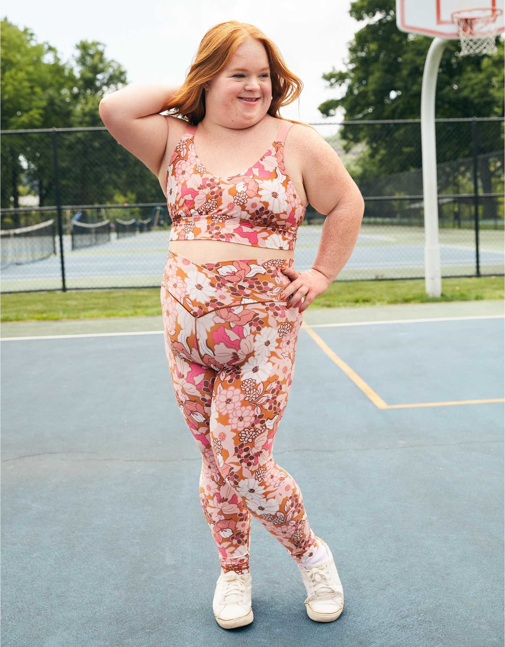 model wearing the floral leggings with matching sports bra and white shoes on a sport court