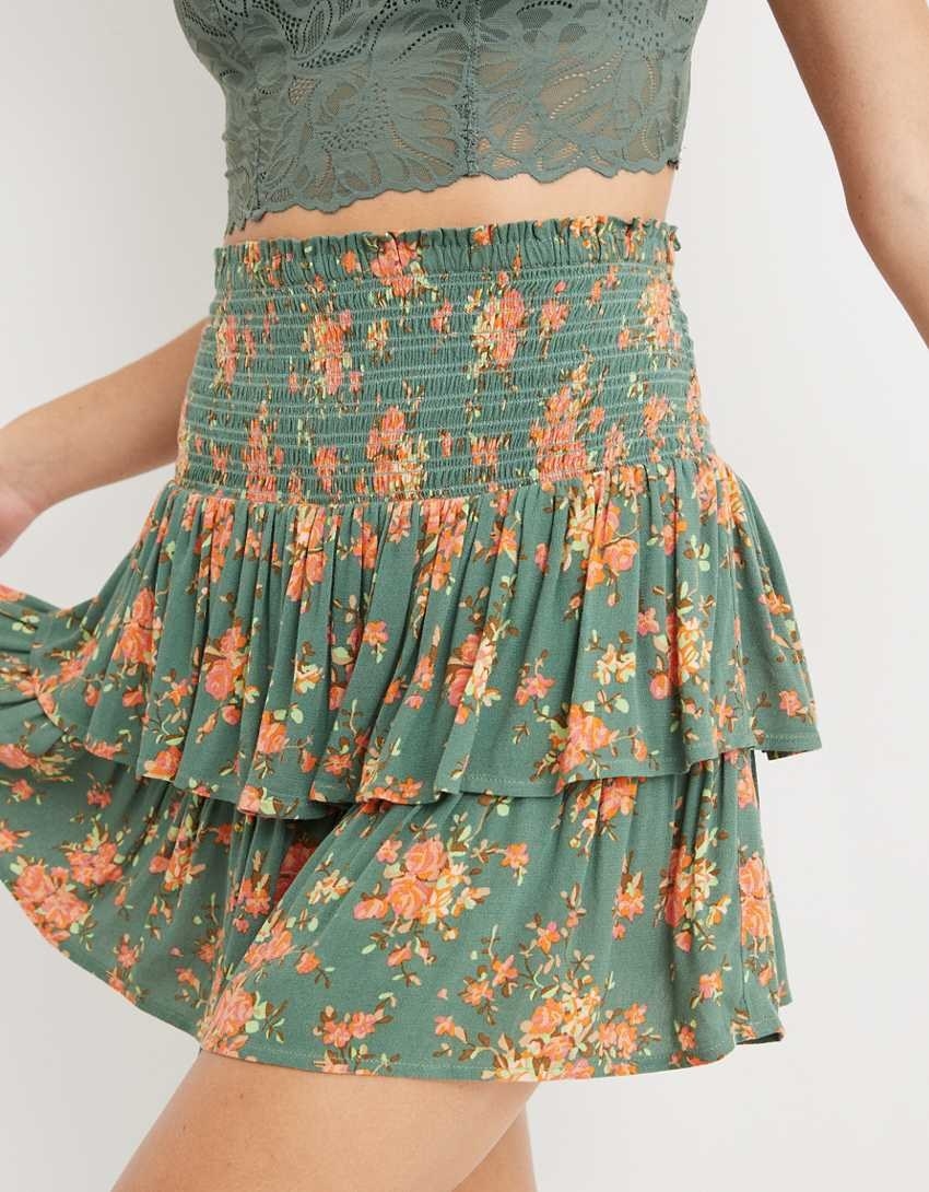 model wearing the skirt in green with ruffles and floral print and a green bralette