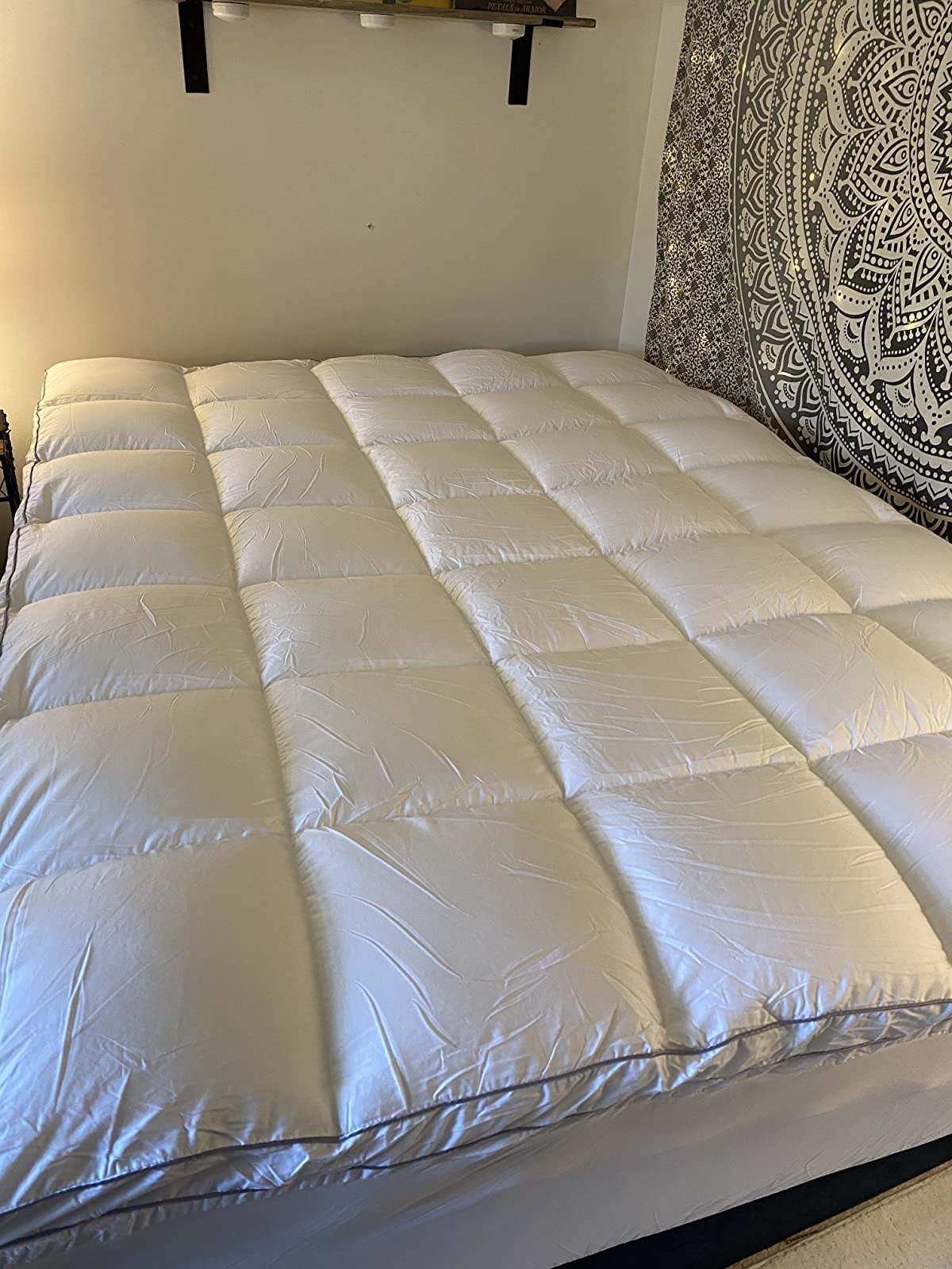 Reviewer photo of the mattress topper on top of their bed