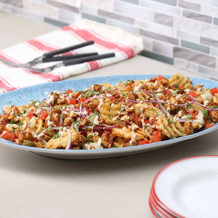 A plate of Shawarma Waffle Fries on a plate on a table.