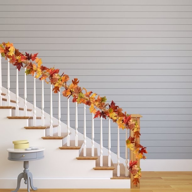 A garland of fall leaves on a banister.