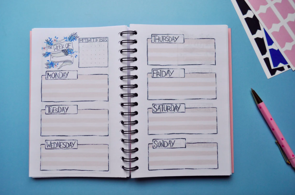 a flatlay of the weekly planner open on a desk