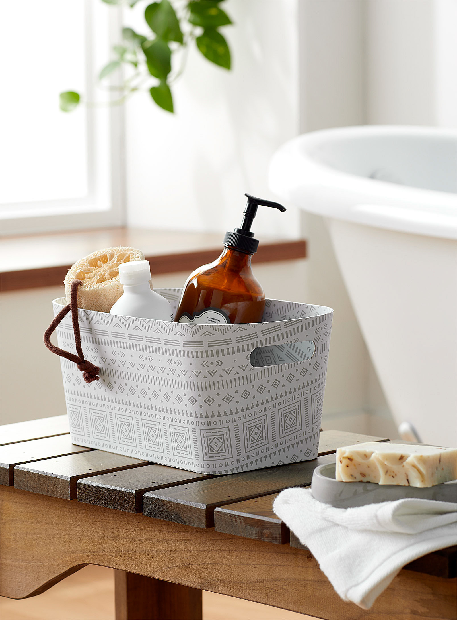 A cardboard basket filled with bathroom items like a sponge, soap, and body wash