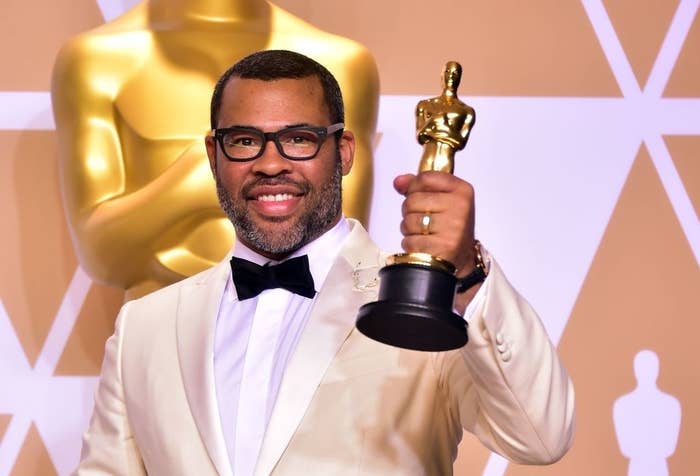 Jordan Peele holding his Oscar