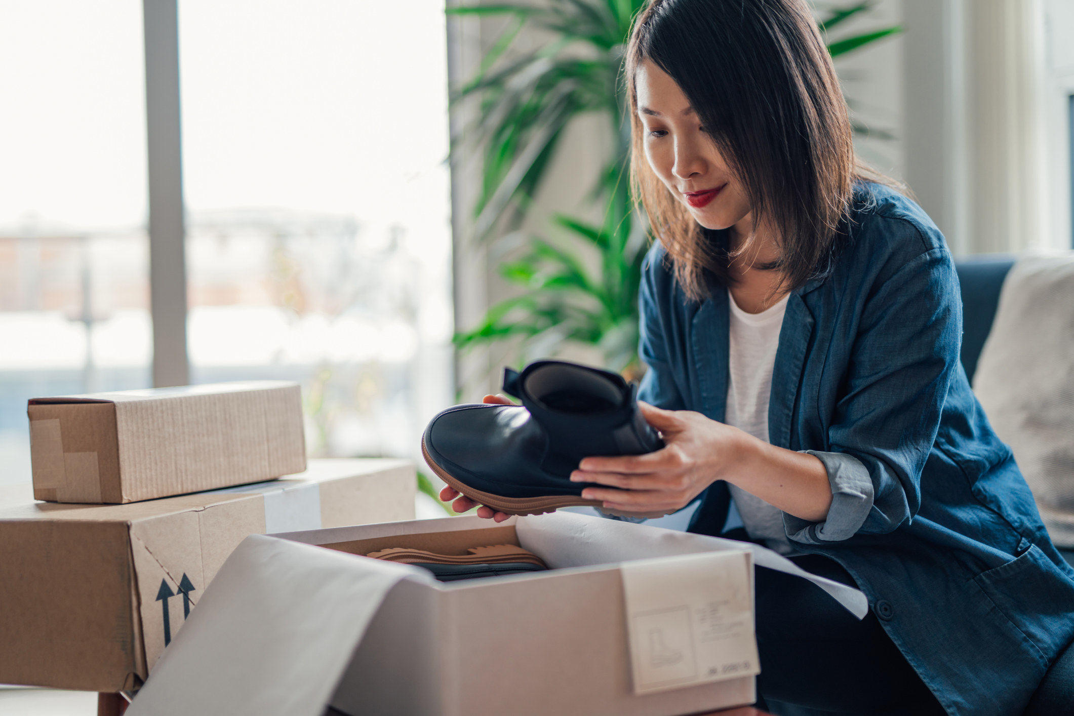 Woman holding a boot from a box