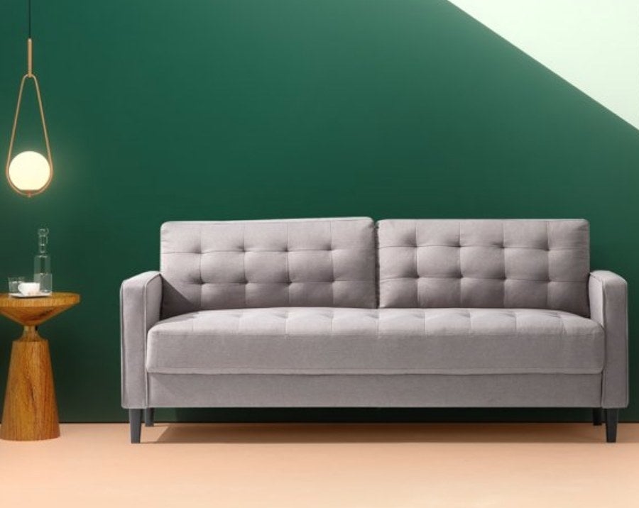 A grey tufted sofa