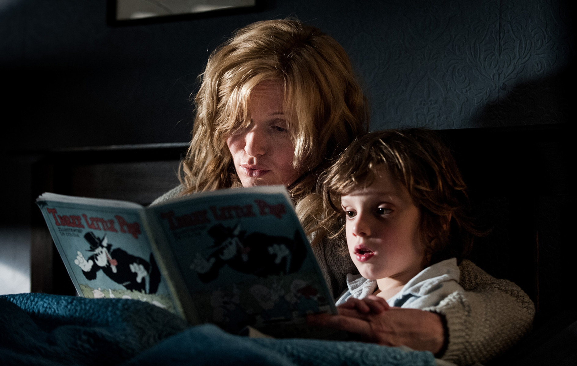 the mother reading a story to her son in bed