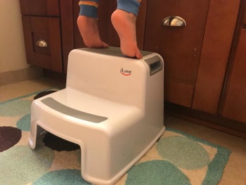 Reviewer's child using the stool for extra height