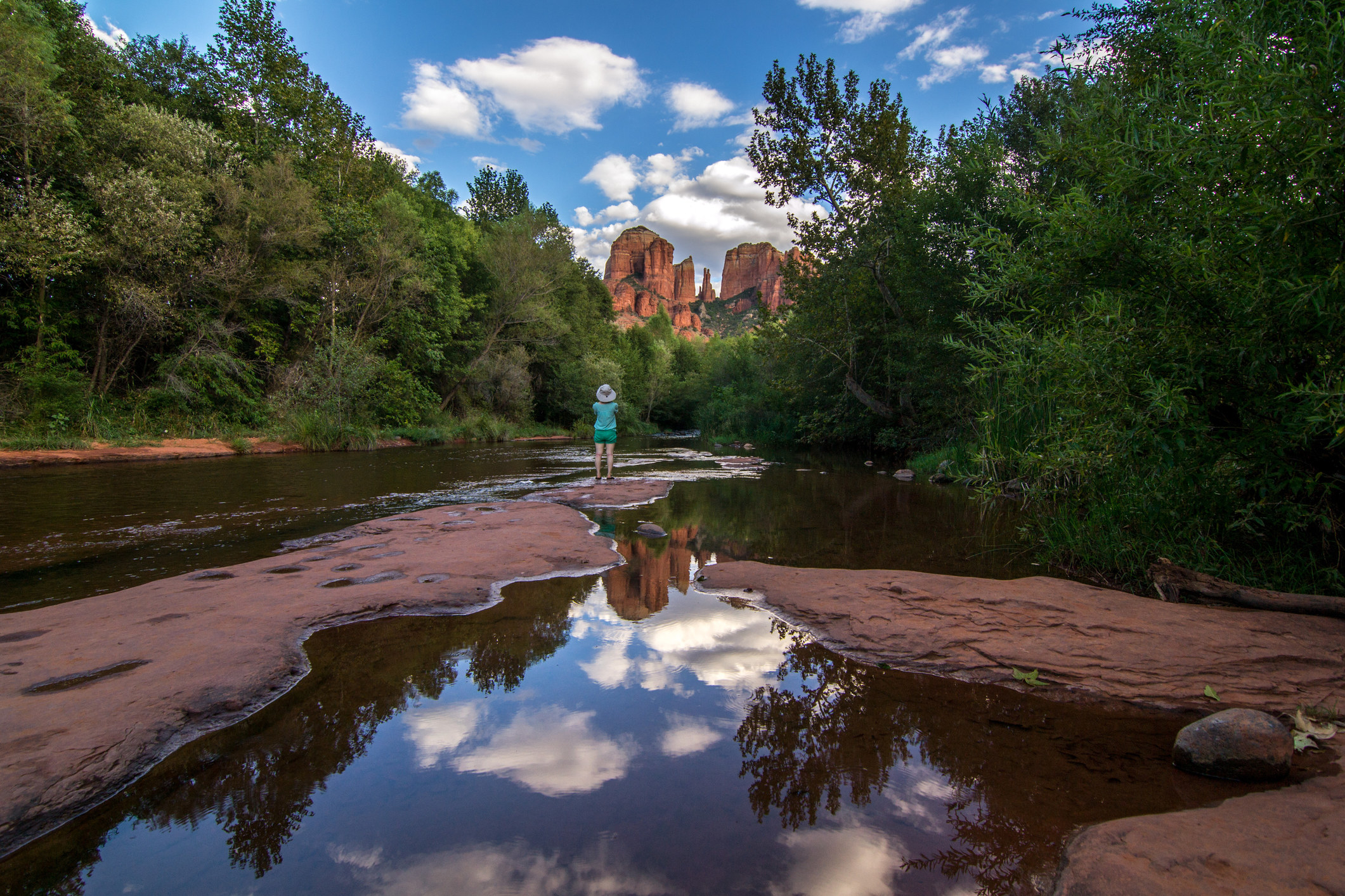 A person hiking in a natural pool in Sedona.