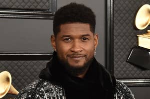 Usher wears a black hoodie and jacket with crystal embellishments on a red carpet