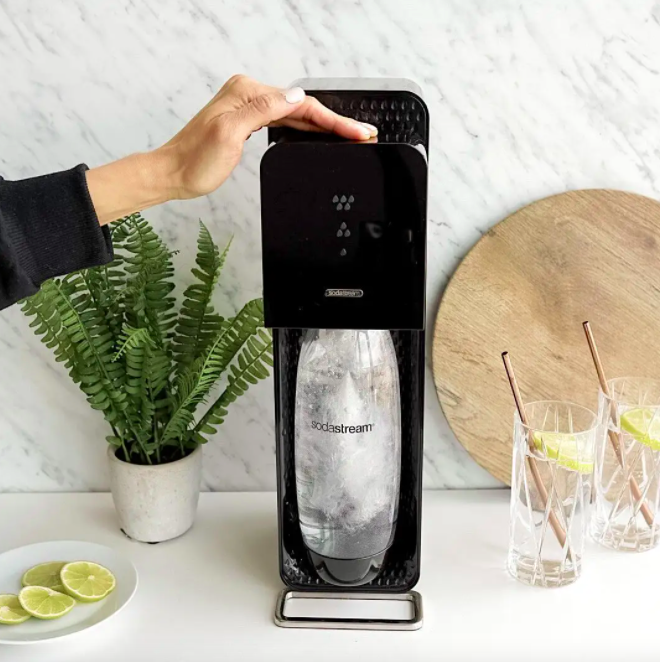 a person using the soda stream to make sparkling water