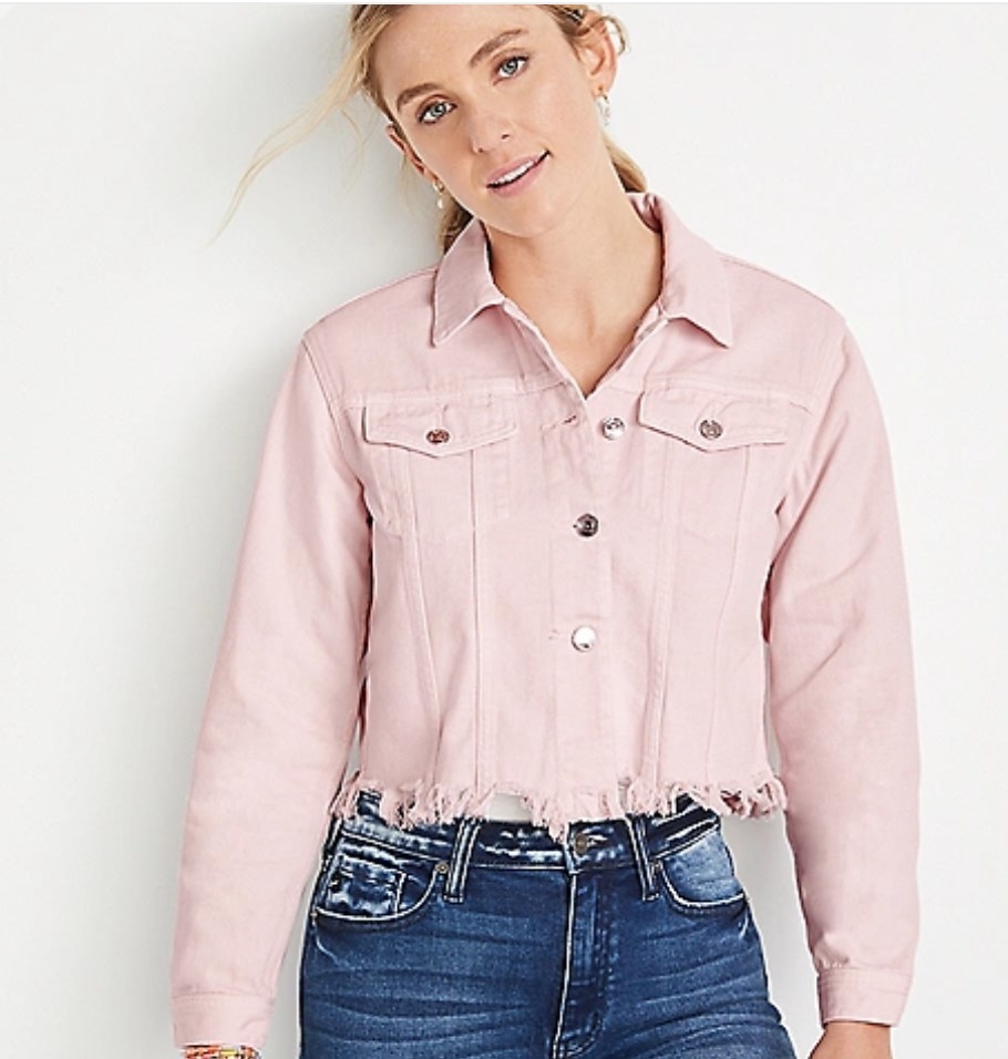 Model wearing pink denim jacket with dark was jeans