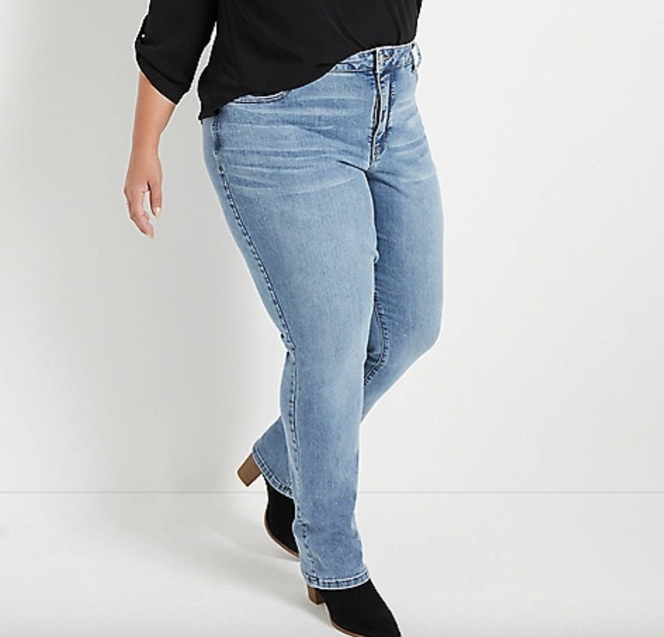 Model wearing lightwash bootcut jeans and black shoes