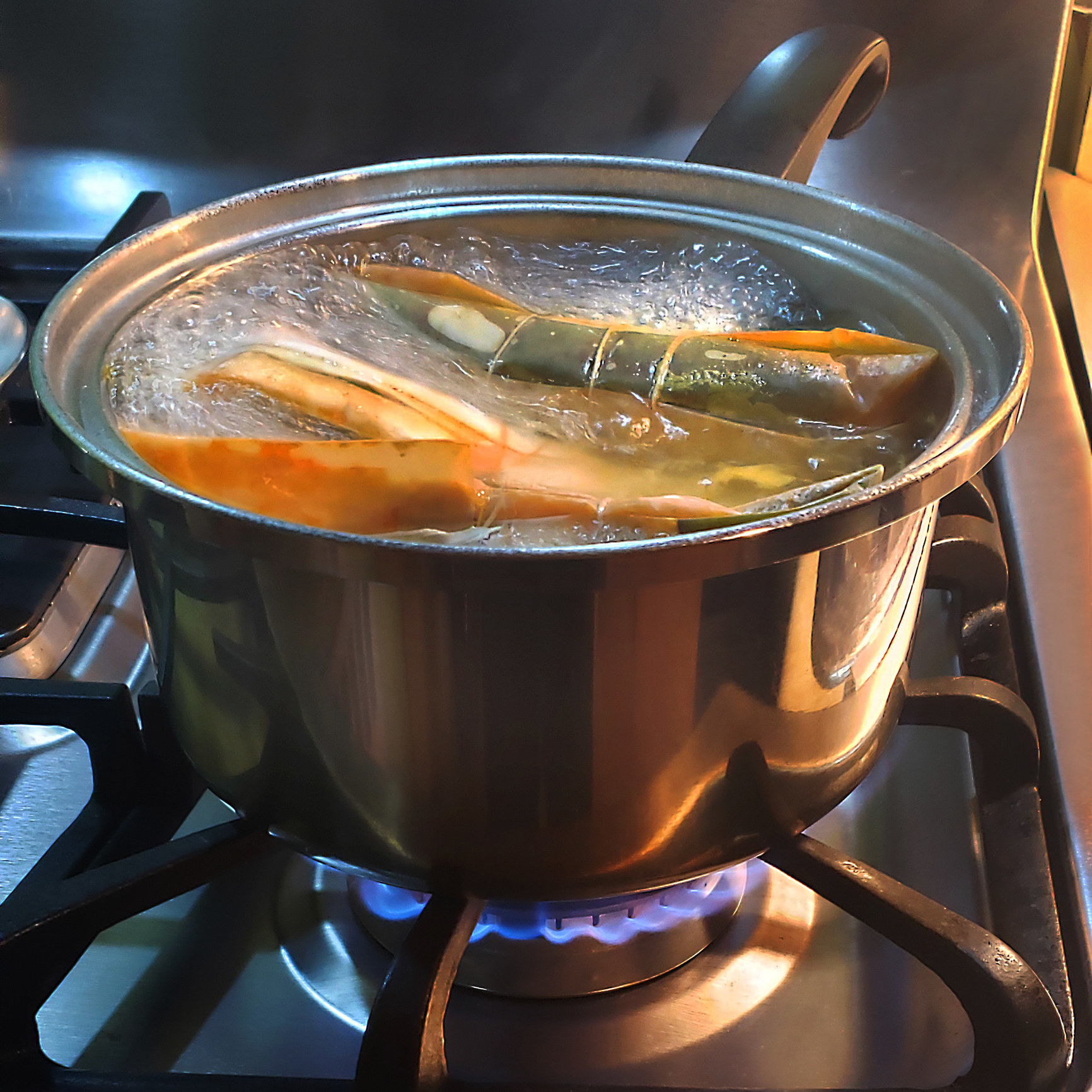 Pasteles cooking in a pot on a stove.